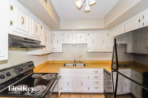 a kitchen with white cabinets and stainless steel appliances and a sink