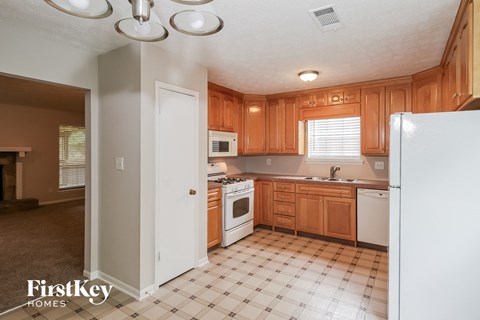 A kitchen with wooden cabinets and a checkered floor.