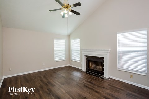 the living room with wood floors and a fireplace