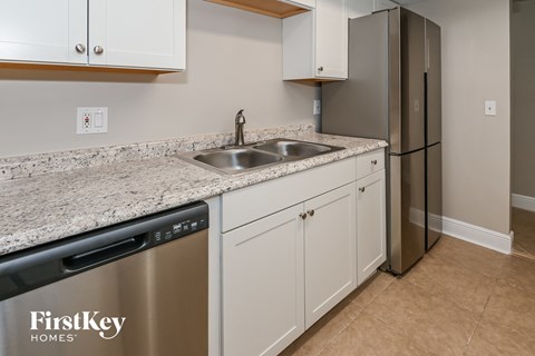 a kitchen with white cabinets and stainless steel appliances and a granite counter top