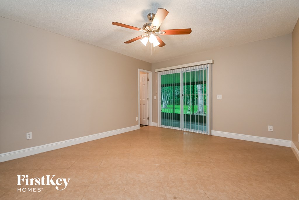 a empty living room with a ceiling fan and a window