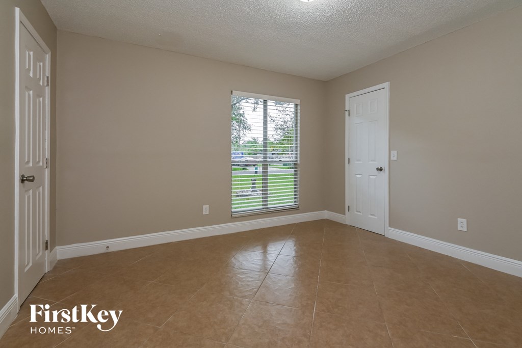 an empty living room with a window and a door to a yard