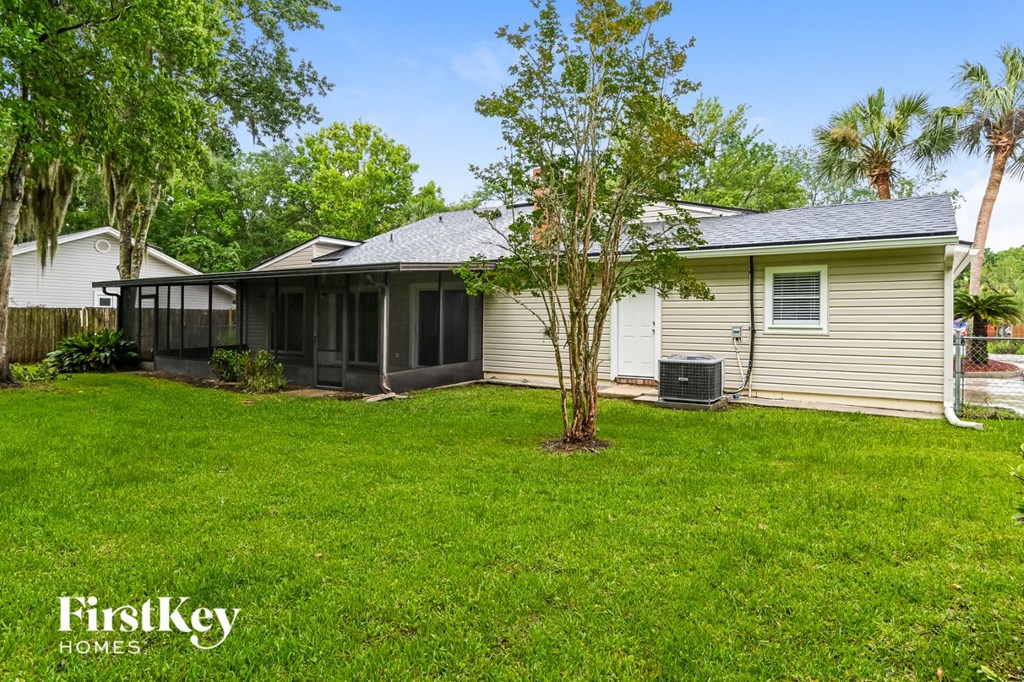 a white house with a screened in porch and a grassy yard