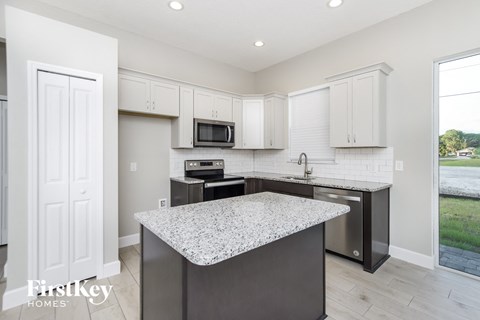 A kitchen with a granite countertop and white cabinets.