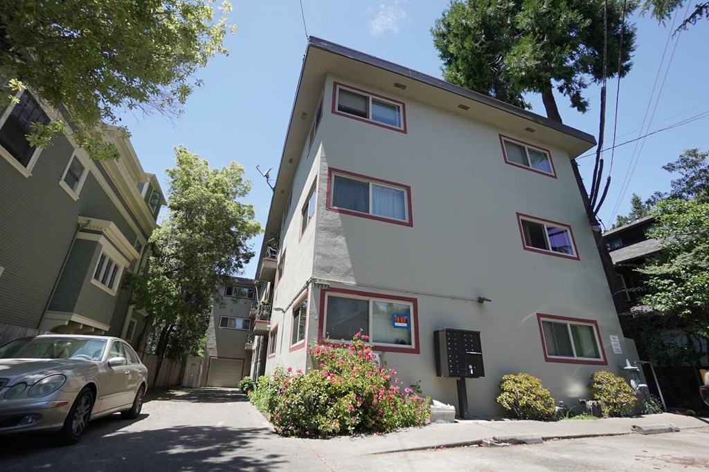a white building with a car parked on a street
