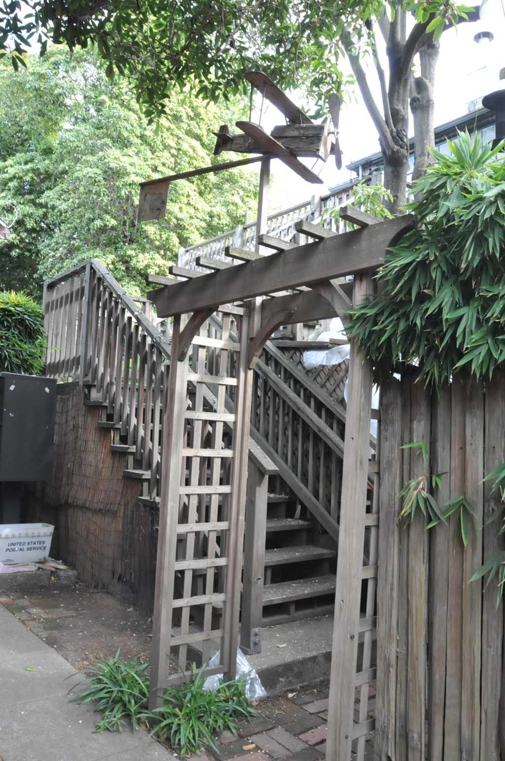 a wooden staircase with an arbor in front of a wooden fence