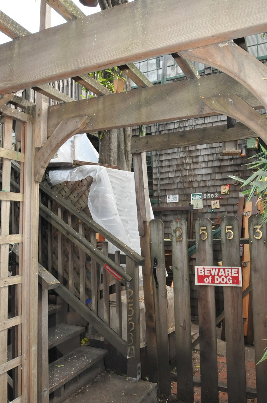 the stairs up to the roof of a building with a beware of dog sign