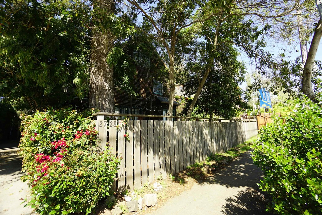 a fence in front of a house with trees