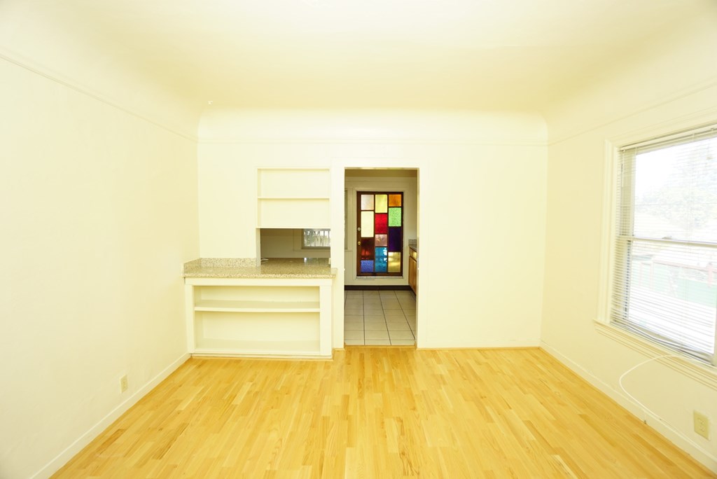a living room with a hard wood floor and a window