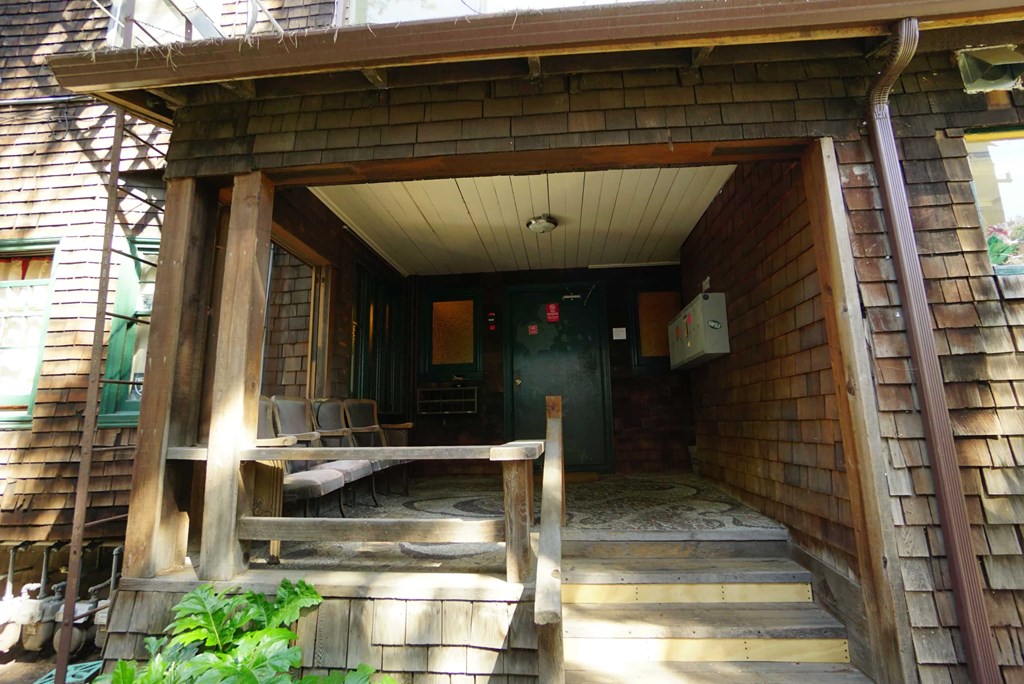 the front porch of a cabin with a porch swing