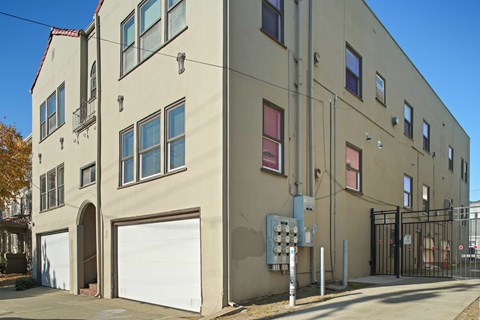A beige building with a white garage door and a black gate.