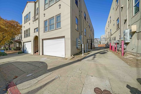 A street view of a residential area with buildings on both sides and a closed garage door.