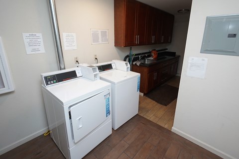 a laundry room with two washers and two dryers in it