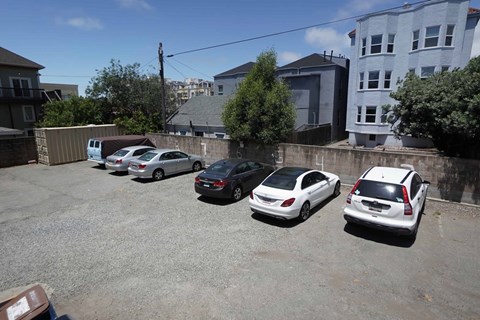 a parking lot filled with cars in front of a house