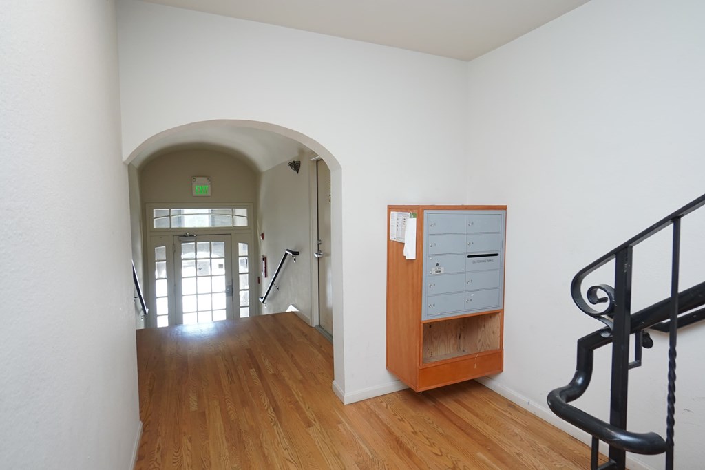 a room with a staircase and a dresser and a door