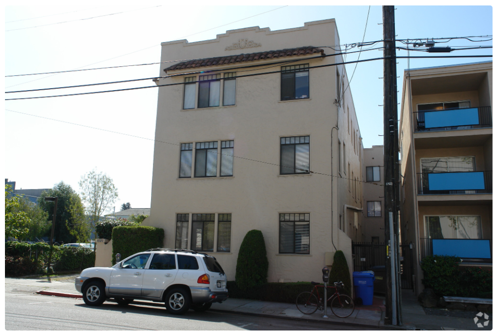 a white car parked in front of an apartment building