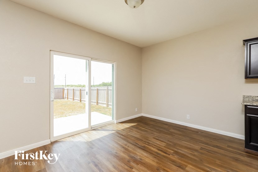 an empty living room with a sliding glass door to a patio