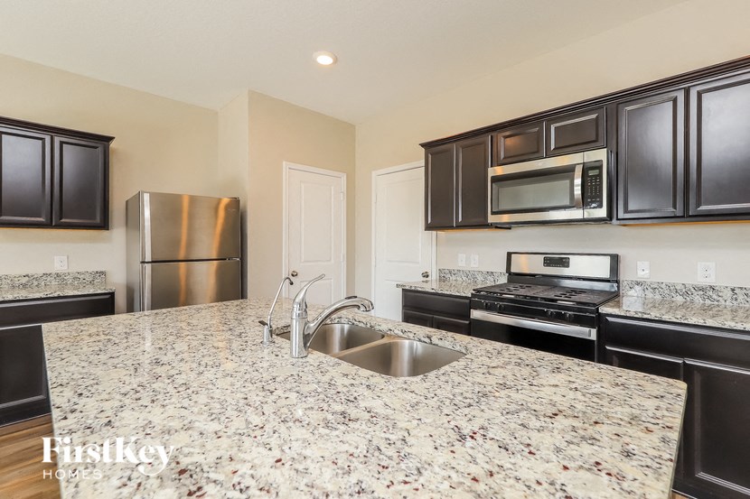 a kitchen with granite counter tops and black appliances