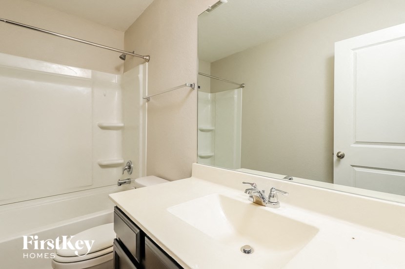 a white bathroom with a sink and a mirror