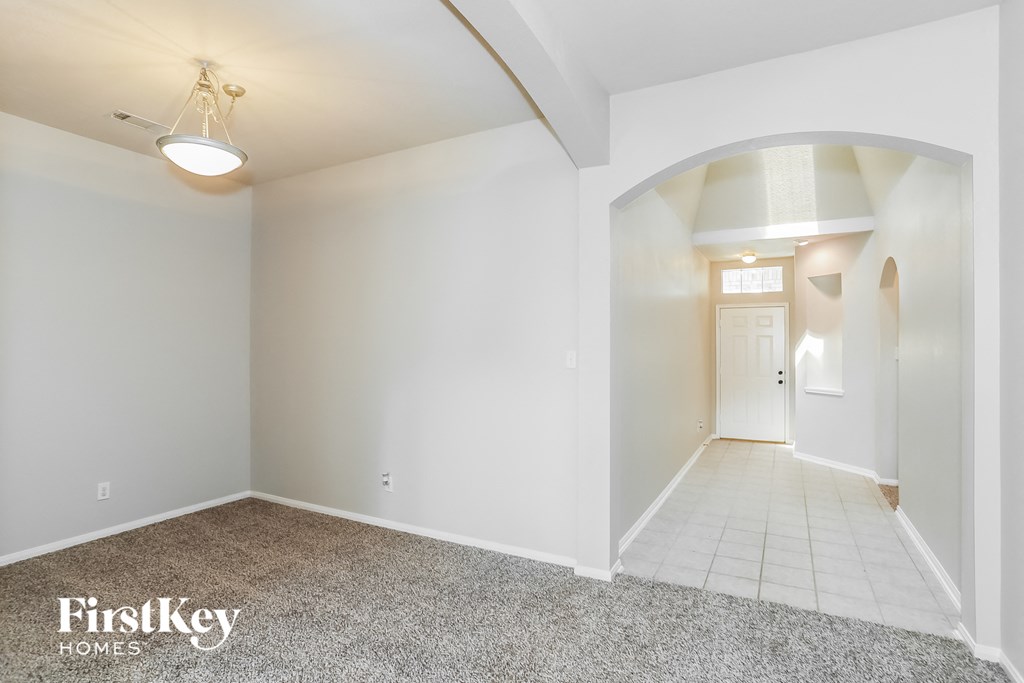 A spacious room with a carpeted floor and a white ceiling.
