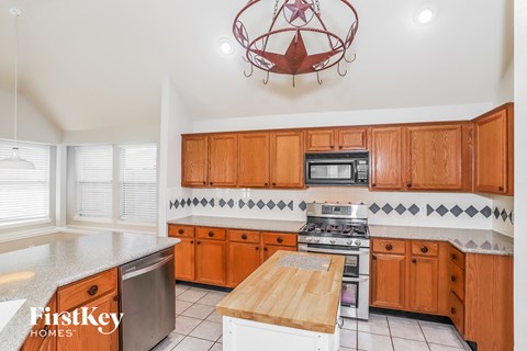 A kitchen with wooden cabinets and a stove top oven.