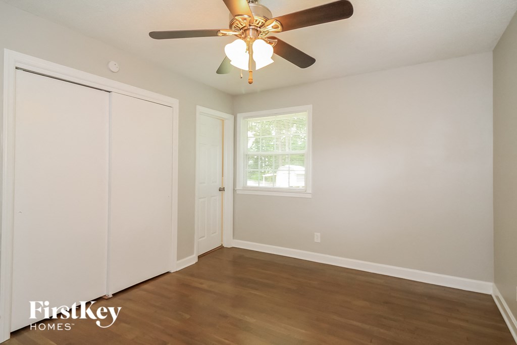 a bedroom with a ceiling fan and a closet