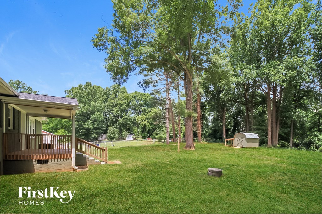 a backyard with a deck and a grill and trees