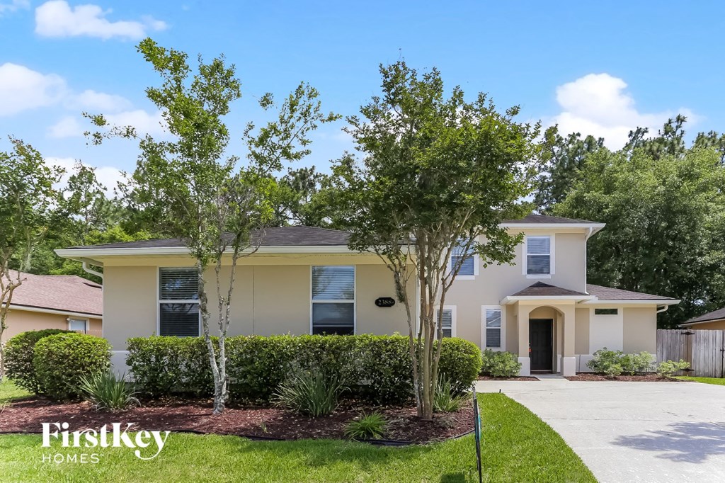 a yellow house with two trees in front of it