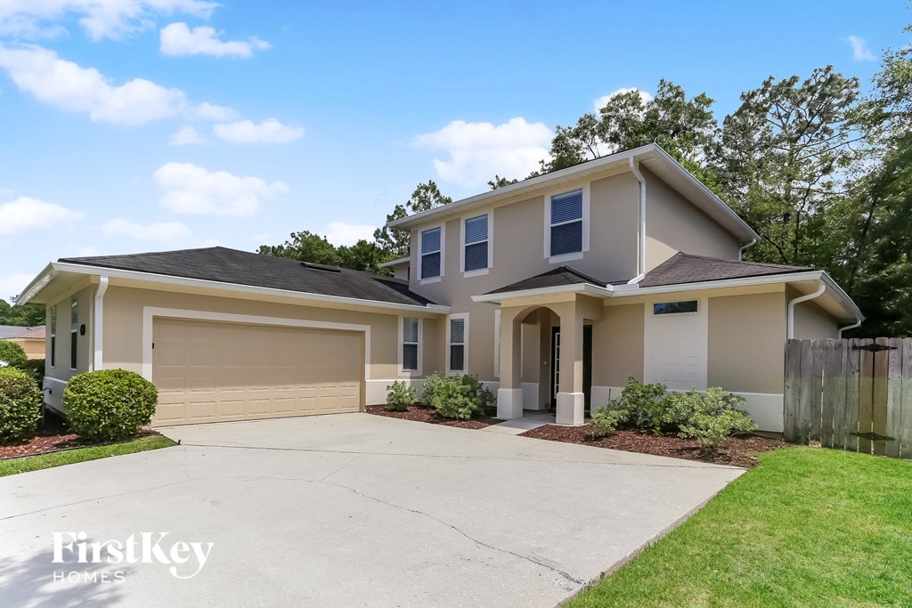 a beige house with a driveway and a garage door