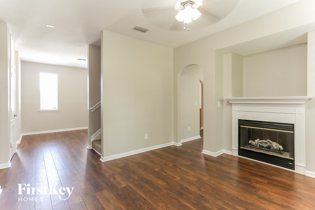 the living room has a fireplace and hardwood floors