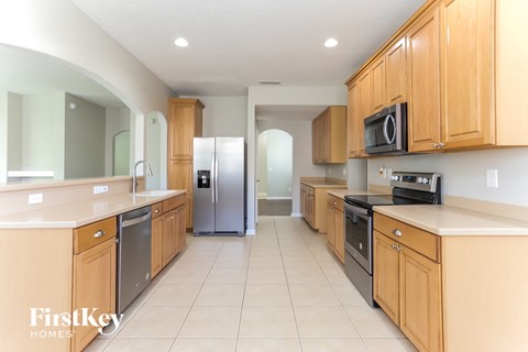a large kitchen with wooden cabinets and stainless steel appliances