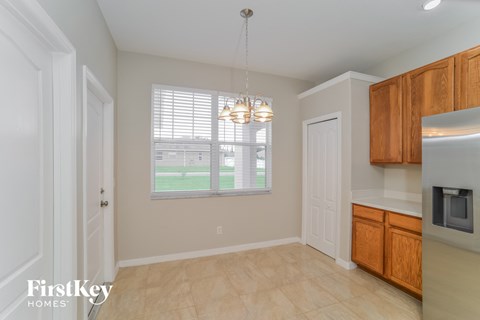 A kitchen with wooden cabinets and a microwave oven.