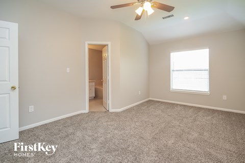 the master bedroom with carpeted flooring and a ceiling fan