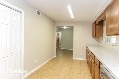 A kitchen with wooden cabinets and a white countertop.
