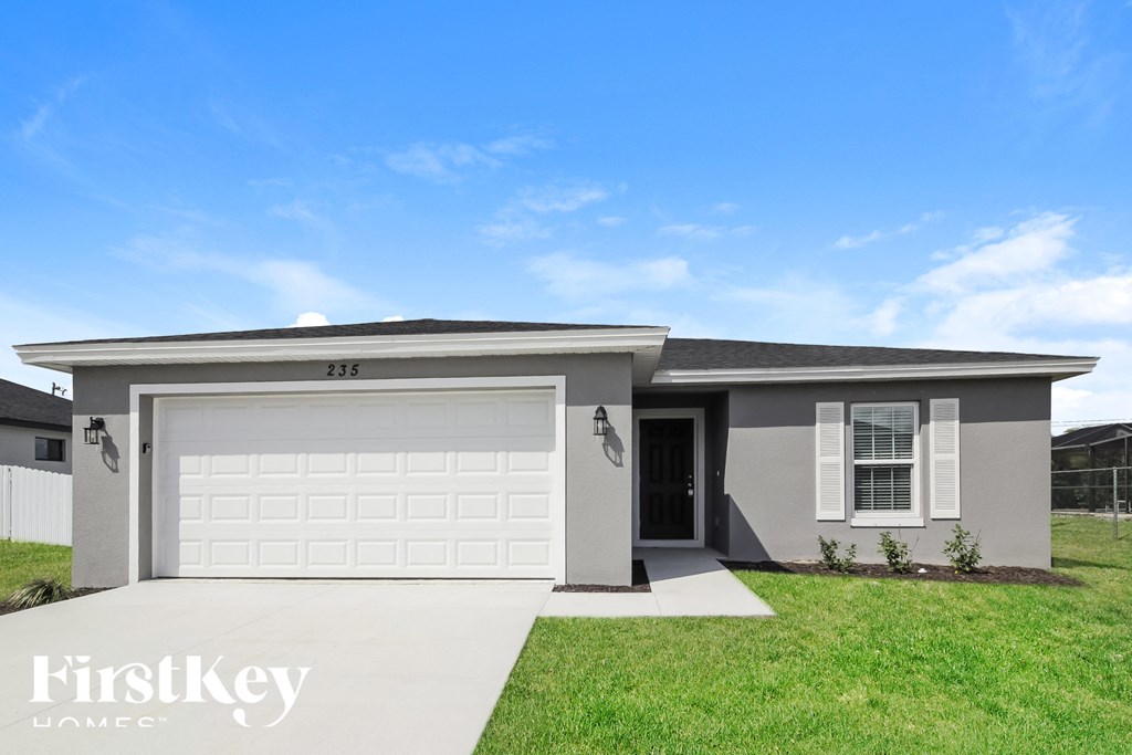 a house with a white garage door and a lawn