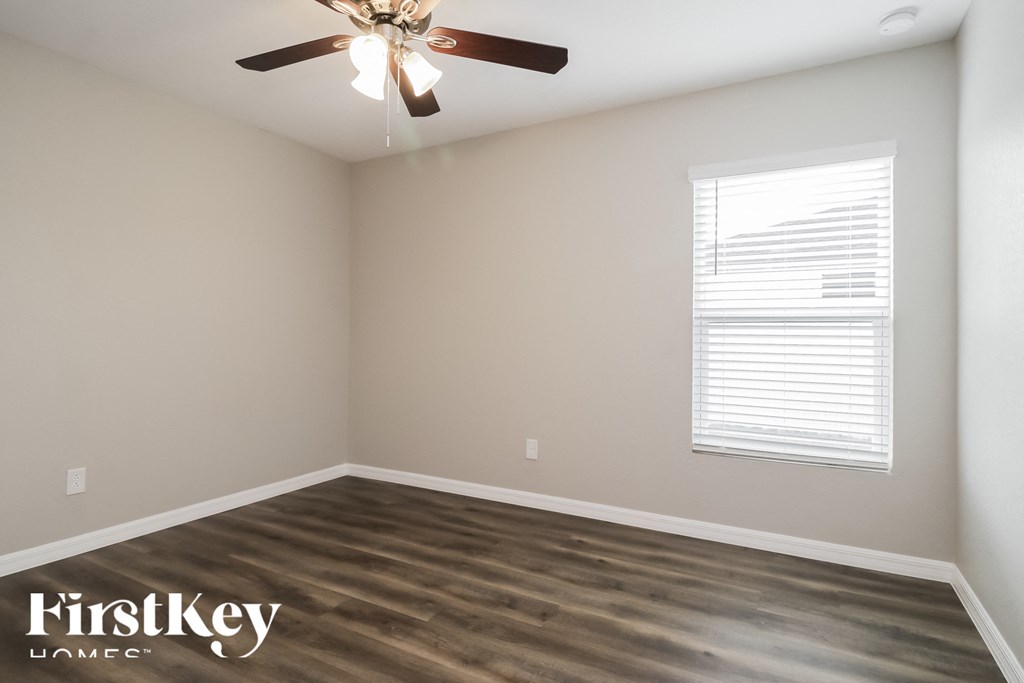 the living room with wood floors and a ceiling fan
