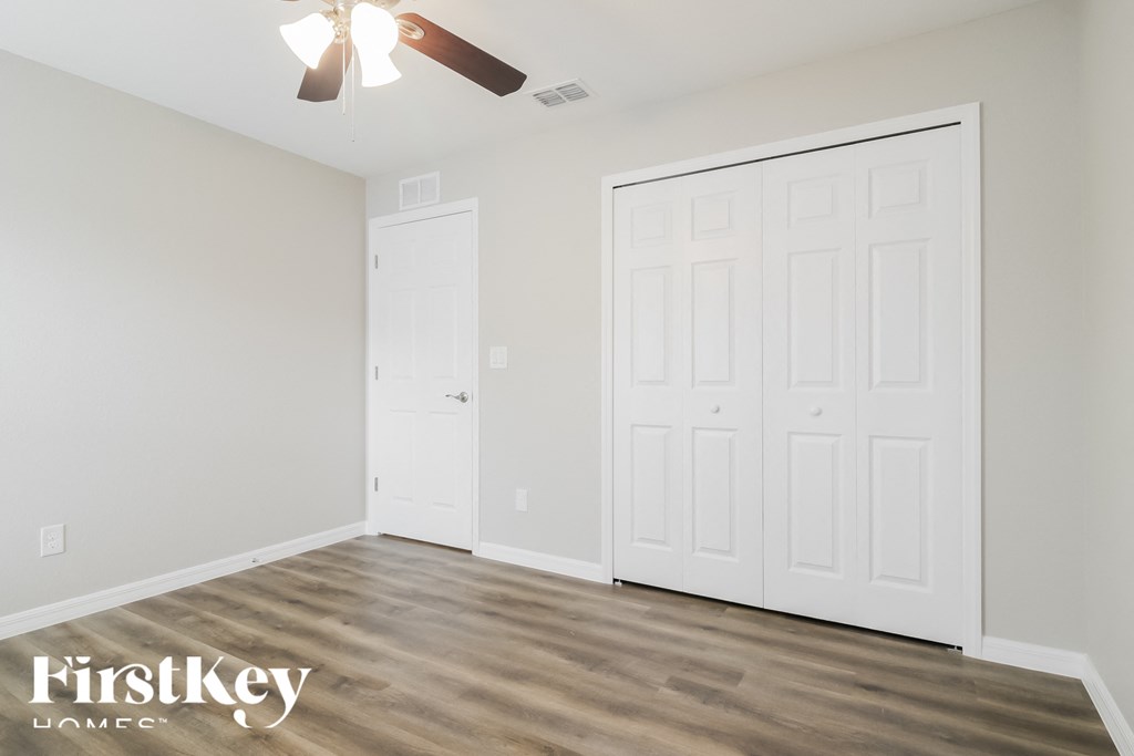 a bedroom with two closets and a ceiling fan