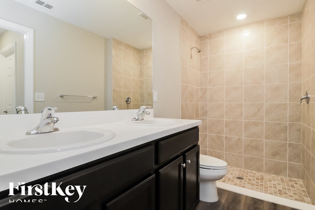a bathroom with a toilet and a sink and a mirror
