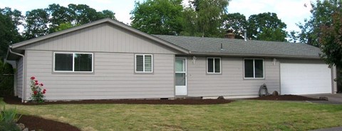 A house with a grey siding and a white garage door.