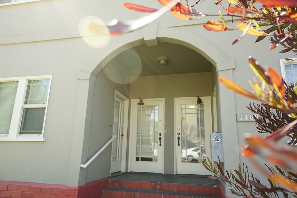 the front entrance of a building with doors and a porch