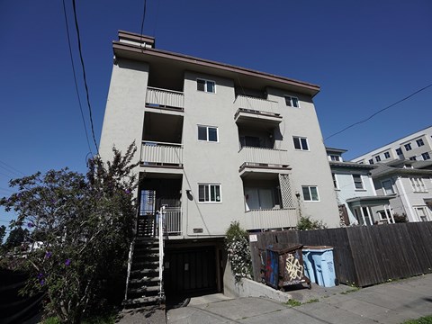 A tall building with a balcony on the second floor.