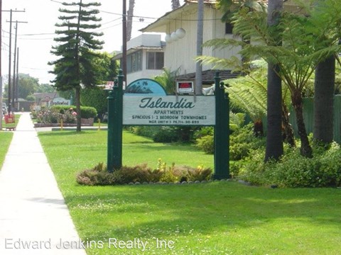 a sign in the grass in front of a house