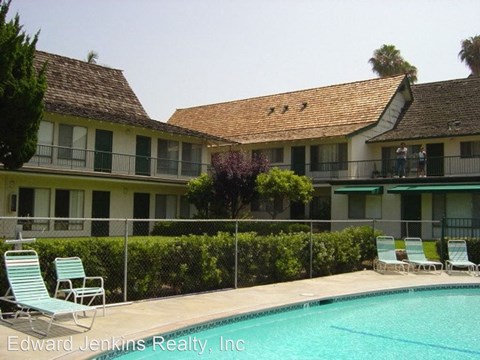 a large swimming pool in front of a hotel with chairs