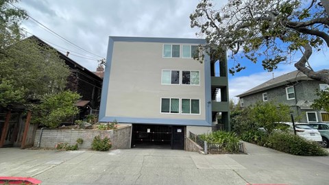 A modern two-story building with a flat roof and a garage door entrance.