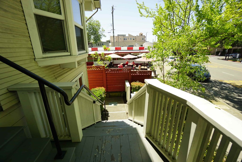 a small porch with a view of a street and a house