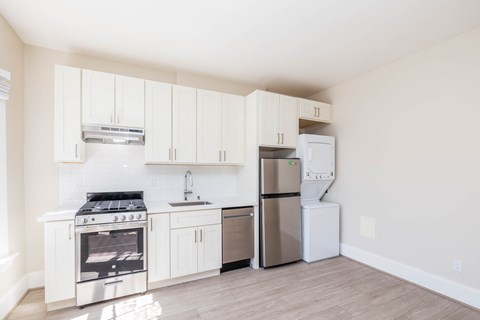 A kitchen with white cabinets and stainless steel appliances.