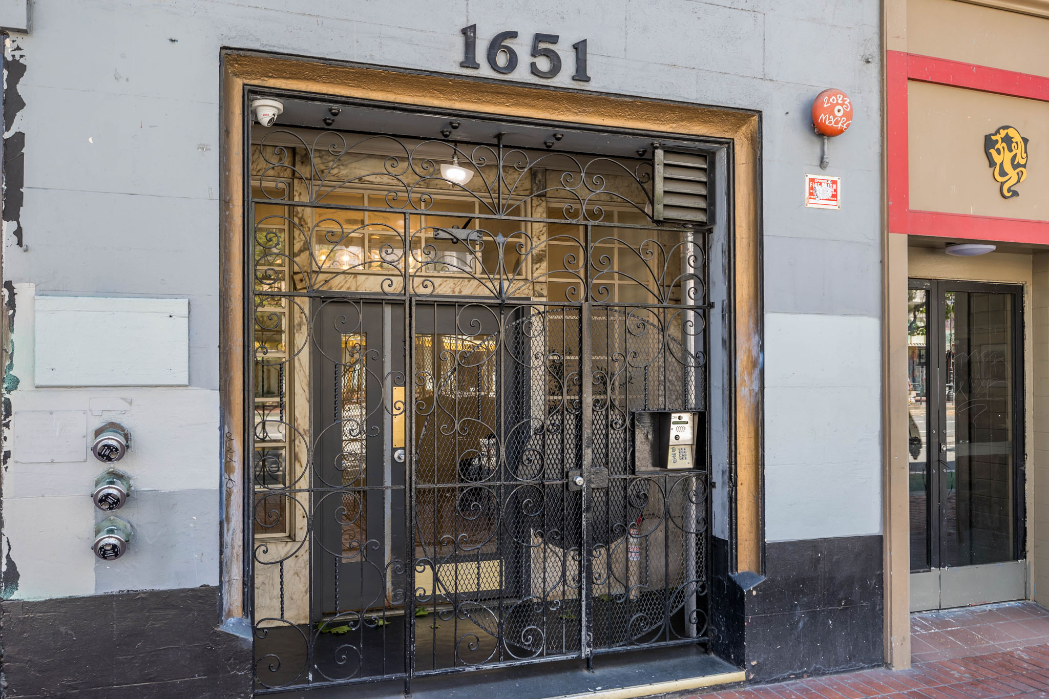 A building with a black gate and a sign that reads 1651.