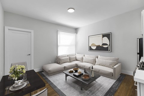 A living room with a couch, coffee table, and a painting on the wall.