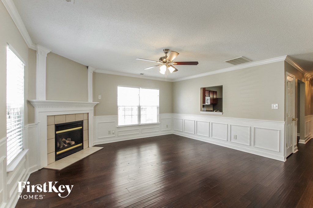 A spacious living room with a fireplace and wood flooring.