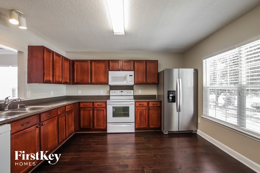 A kitchen with wooden cabinets and a stainless steel refrigerator.